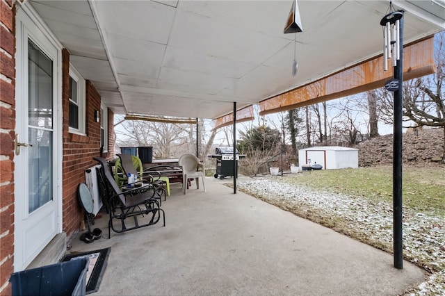 view of patio / terrace featuring grilling area, a storage shed, and an outdoor structure