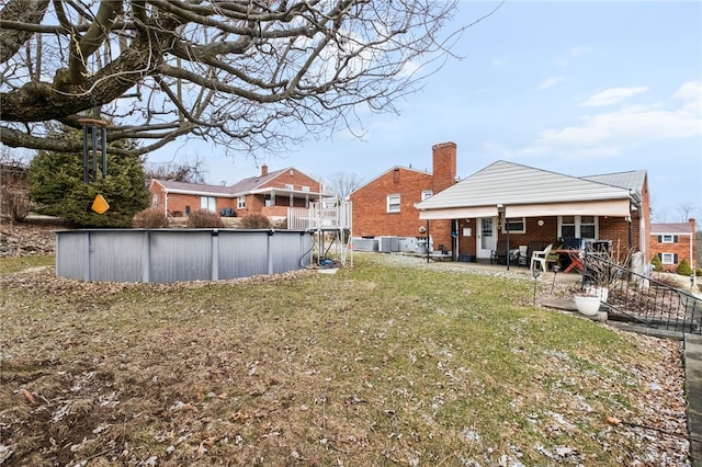 view of yard with a patio, an outdoor pool, and central AC