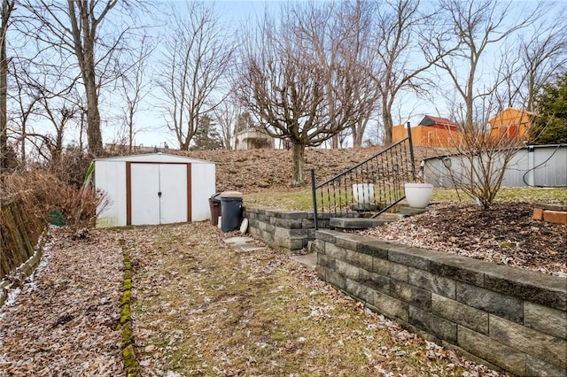 view of yard with fence, an outbuilding, stairs, and a shed