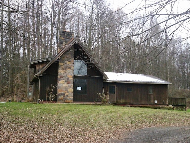 view of property exterior featuring a lawn and a chimney