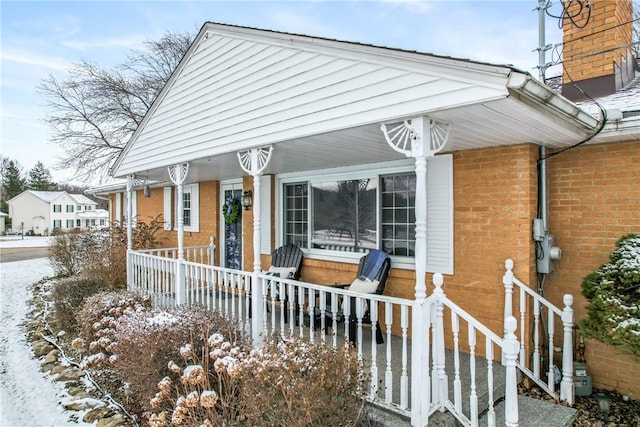 view of front of property featuring brick siding and a porch