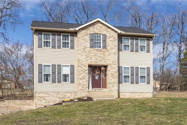 colonial house featuring brick siding and a front lawn