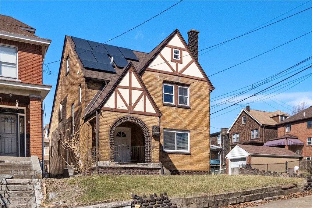 527 Verona St, Braddock, PA 15104 - english style home with stucco siding, fence, brick siding, solar panels, and a chimney