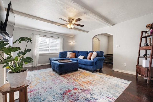 living area featuring beamed ceiling, a ceiling fan, wood finished floors, arched walkways, and baseboards