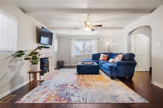 living area with visible vents, beam ceiling, arched walkways, wood-type flooring, and baseboards