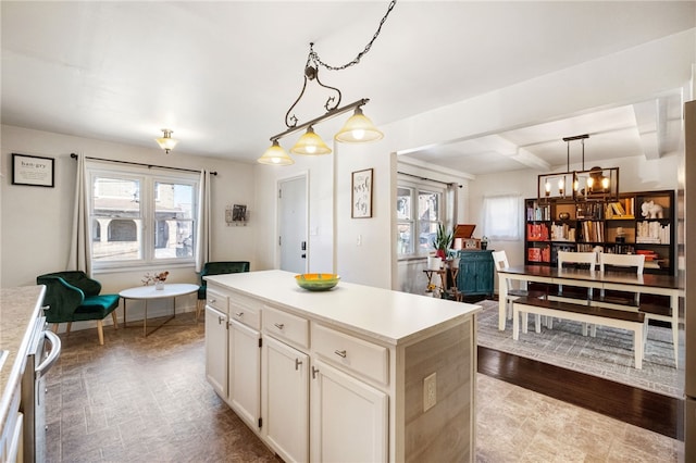 kitchen featuring decorative light fixtures, white cabinets, a center island, and light countertops