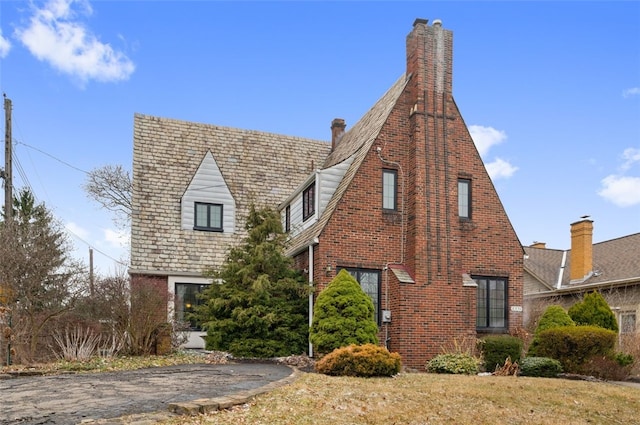 view of front of house with brick siding and a chimney