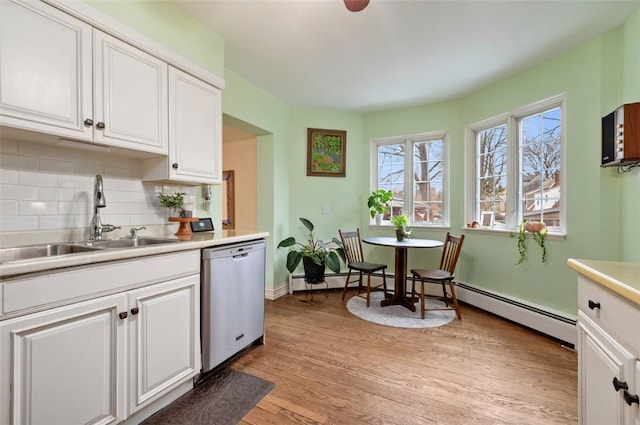 kitchen with a sink, backsplash, white cabinetry, and stainless steel dishwasher