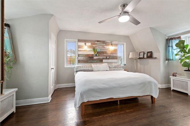 bedroom with multiple windows, radiator heating unit, baseboards, and wood finished floors