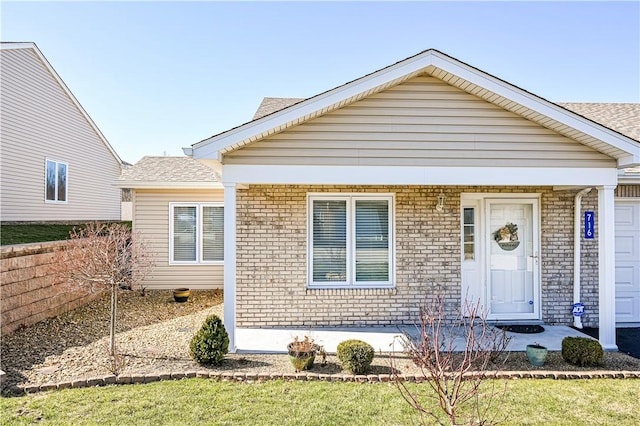 bungalow-style house with brick siding and a shingled roof