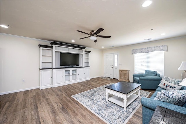 living area with recessed lighting, baseboards, wood finished floors, and ornamental molding