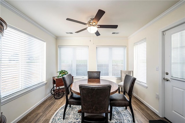 dining space featuring visible vents, wood finished floors, and ornamental molding