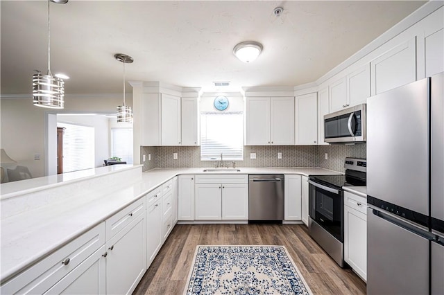 kitchen with tasteful backsplash, dark wood-type flooring, light countertops, appliances with stainless steel finishes, and white cabinetry