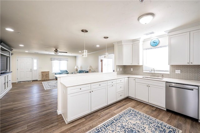 kitchen with a sink, stainless steel dishwasher, open floor plan, a peninsula, and light countertops