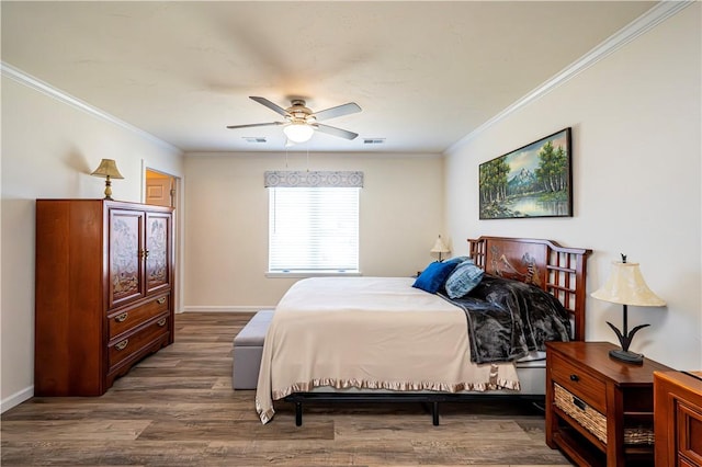 bedroom featuring visible vents, wood finished floors, baseboards, and ornamental molding