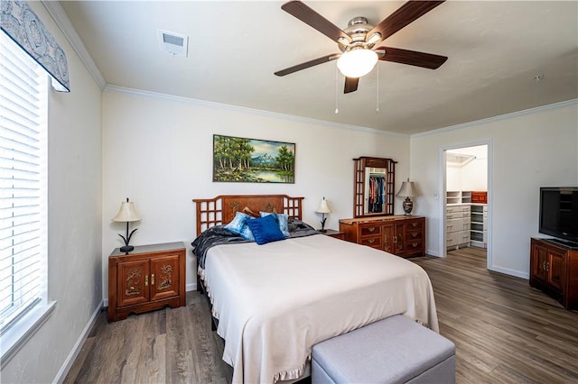 bedroom featuring crown molding, wood finished floors, visible vents, and baseboards