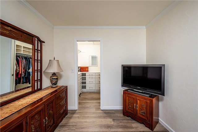 interior space featuring ornamental molding, baseboards, and wood finished floors