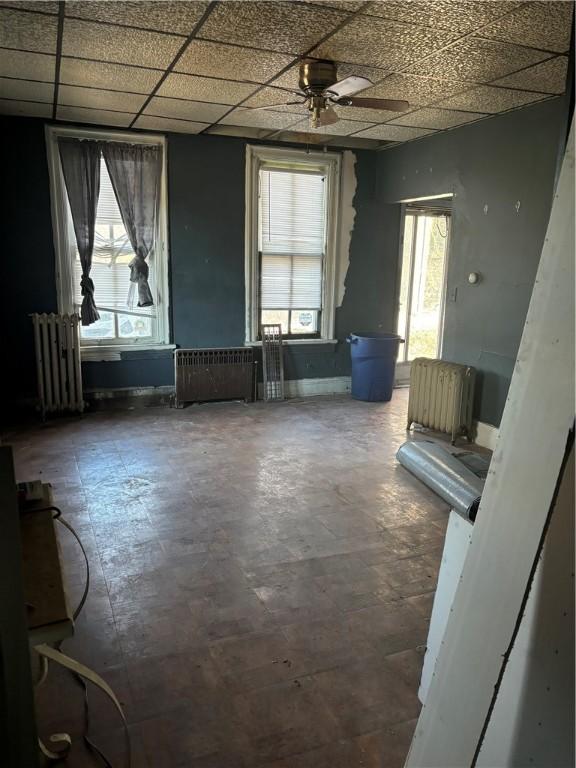 unfurnished room featuring a wealth of natural light, radiator, and radiator heating unit