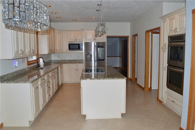 kitchen featuring light stone countertops, appliances with stainless steel finishes, a center island, and a sink