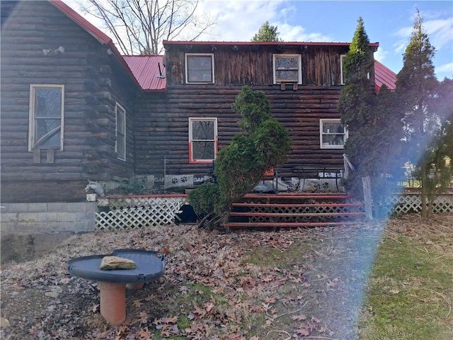 cabin with log siding and metal roof