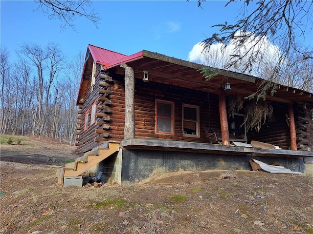 view of home's exterior featuring metal roof and log exterior