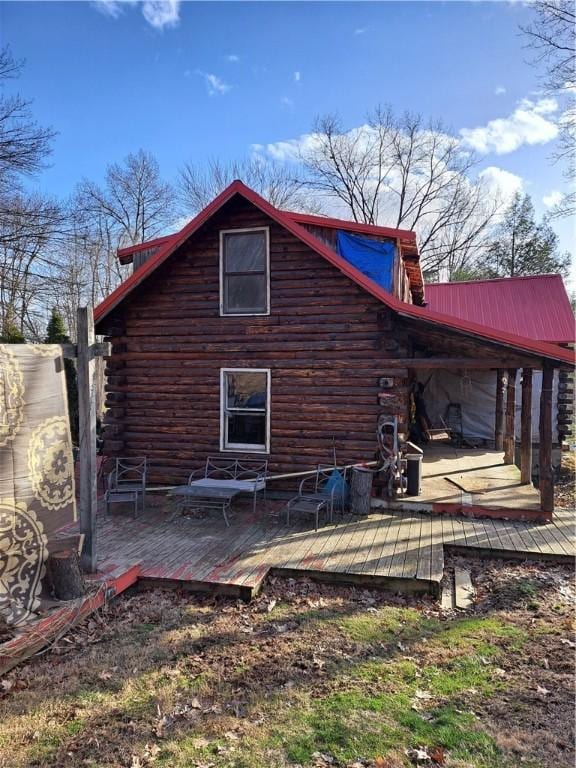 back of property with a deck, log siding, and metal roof