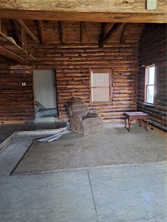 interior space with log walls, wooden ceiling, and vaulted ceiling with beams