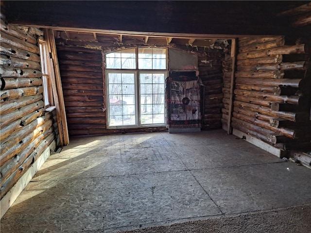 unfurnished living room with log walls