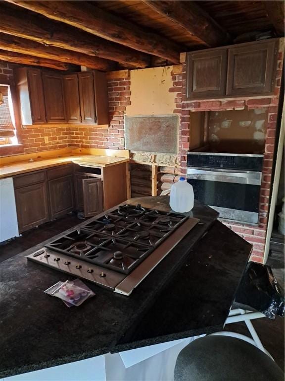 kitchen with beamed ceiling, tasteful backsplash, and appliances with stainless steel finishes