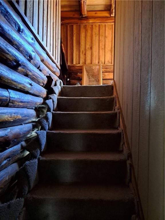 staircase featuring rustic walls