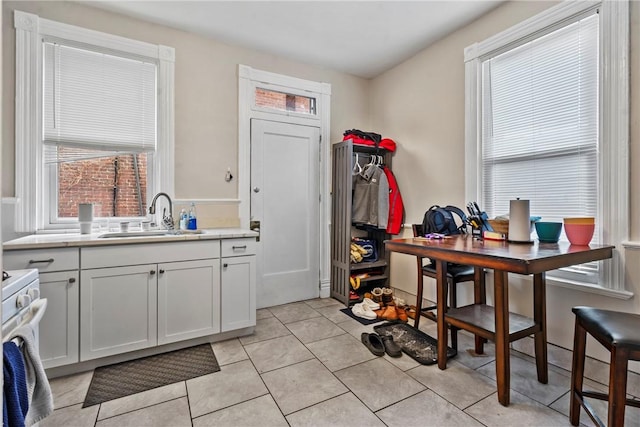 kitchen featuring light countertops, light tile patterned flooring, a wealth of natural light, and a sink