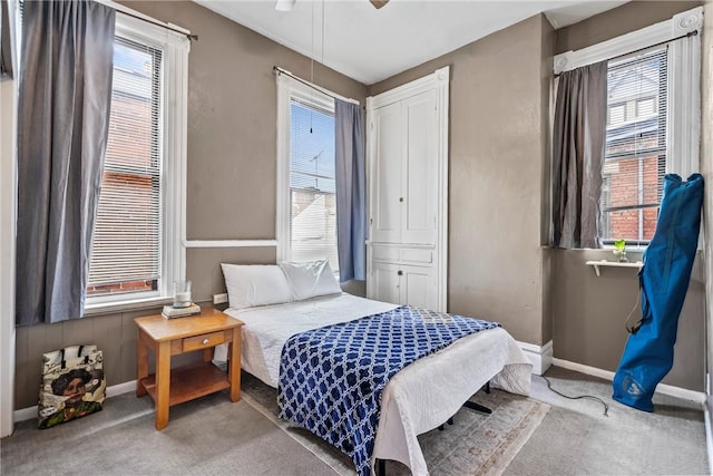 bedroom with baseboards, multiple windows, carpet floors, and ceiling fan