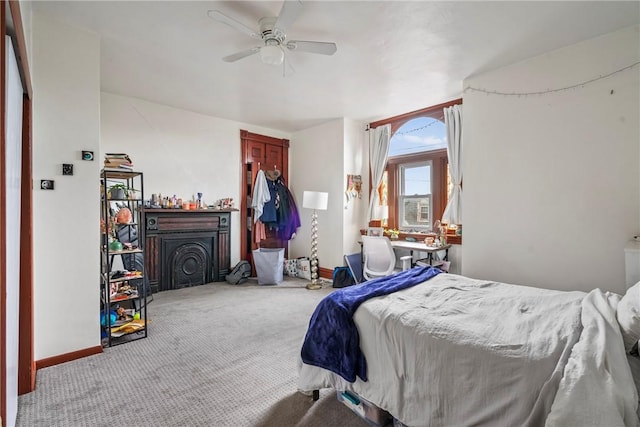 carpeted bedroom featuring baseboards and ceiling fan