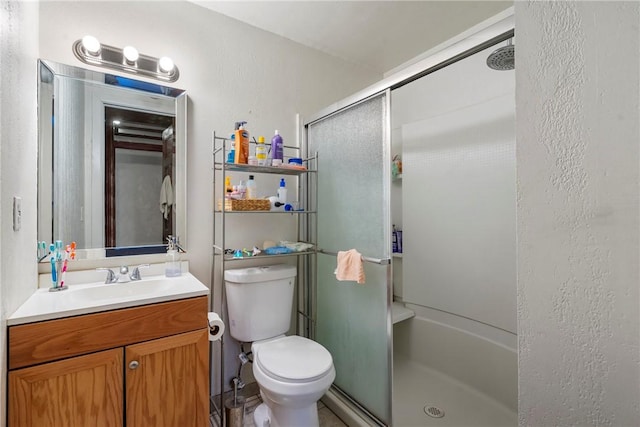 full bathroom with a shower stall, toilet, and vanity