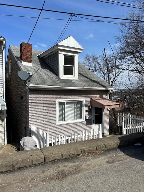 view of front of house with fence and roof with shingles