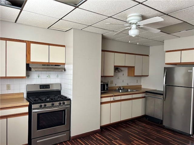 kitchen featuring under cabinet range hood, light countertops, appliances with stainless steel finishes, and a sink