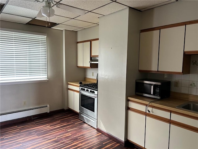 kitchen with dark wood-type flooring, backsplash, stainless steel appliances, baseboards, and baseboard heating