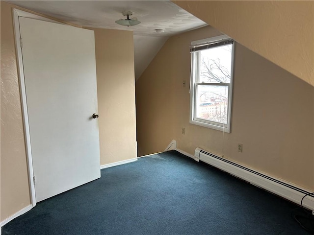 additional living space featuring dark colored carpet, a baseboard radiator, lofted ceiling, and baseboards