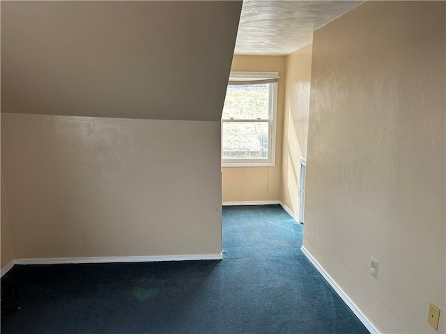 bonus room featuring vaulted ceiling, baseboards, and dark carpet