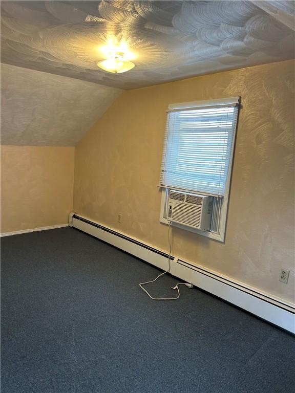 bonus room with vaulted ceiling, cooling unit, baseboard heating, and carpet floors