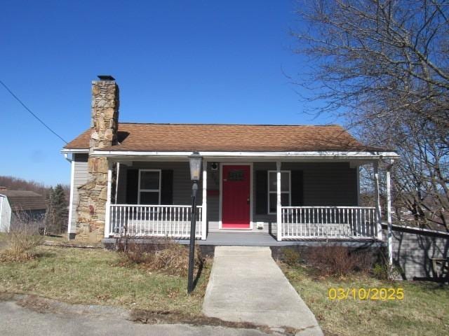 bungalow-style house with covered porch, a chimney, and roof with shingles