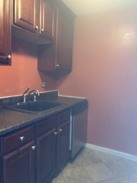 kitchen with dishwasher, light tile patterned floors, baseboards, and a sink