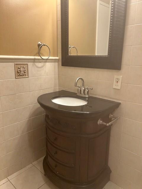 bathroom featuring a wainscoted wall, tile walls, vanity, and tile patterned flooring