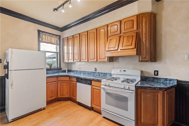 kitchen with crown molding, brown cabinets, light wood-style floors, white appliances, and a sink