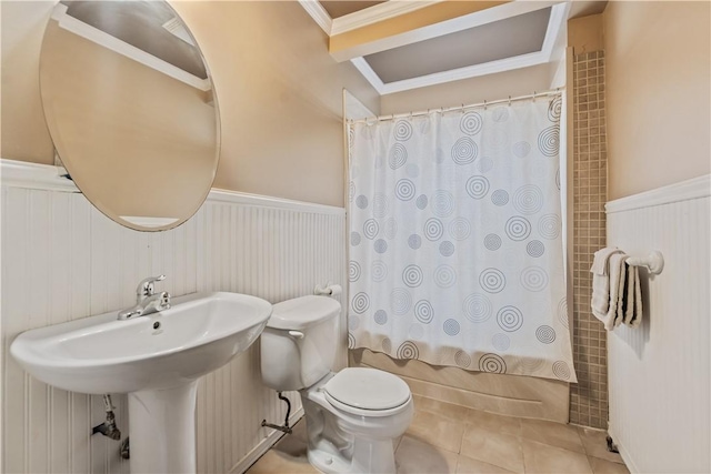 full bath with a wainscoted wall, toilet, shower / tub combo with curtain, ornamental molding, and tile patterned floors