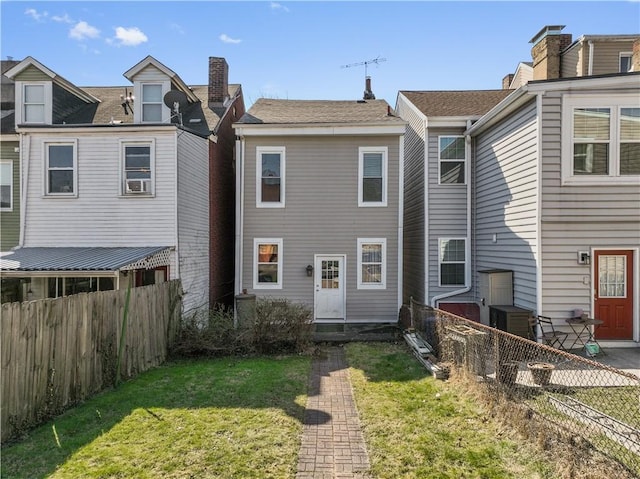 view of front of home with a fenced backyard and a front lawn