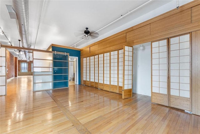 empty room with wood-type flooring and a ceiling fan