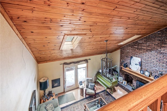 living area featuring vaulted ceiling with skylight, wooden ceiling, and wood finished floors