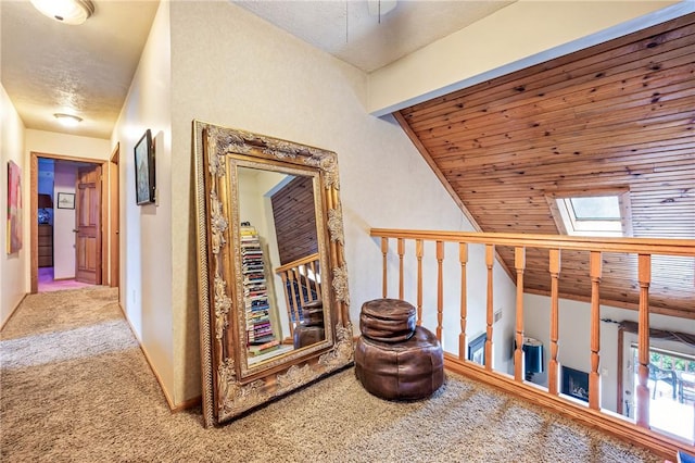 hallway featuring a skylight and carpet flooring