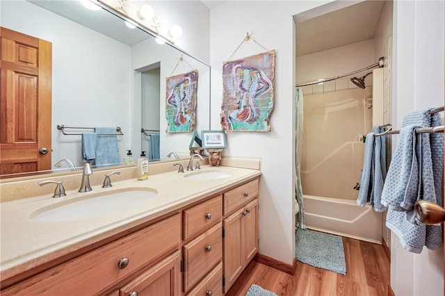 bathroom featuring double vanity, wood finished floors, shower / tub combo, and a sink